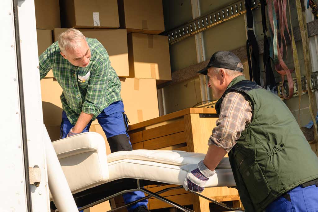 Professional team wrapping and packing furniture for secure storage